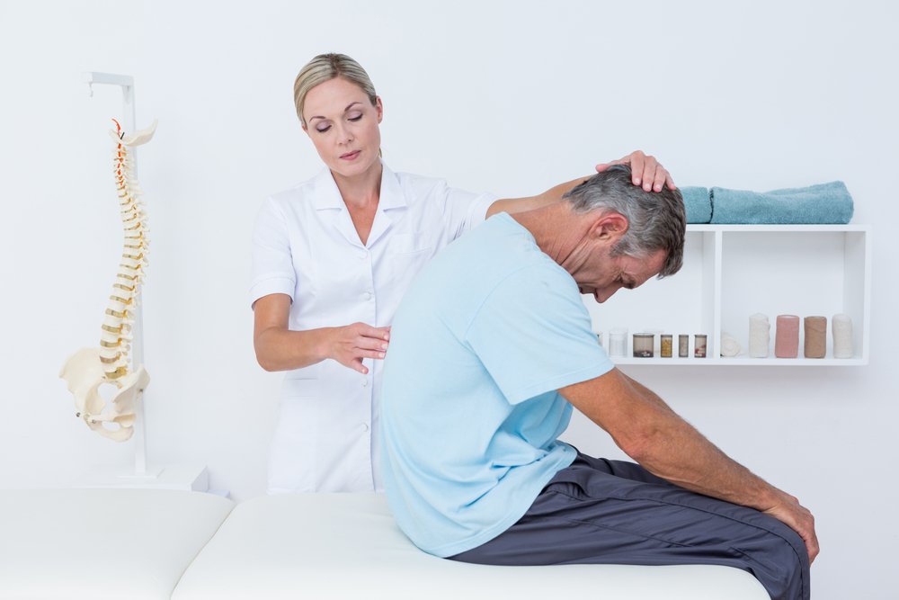 a chiropractor examines a patient's spine